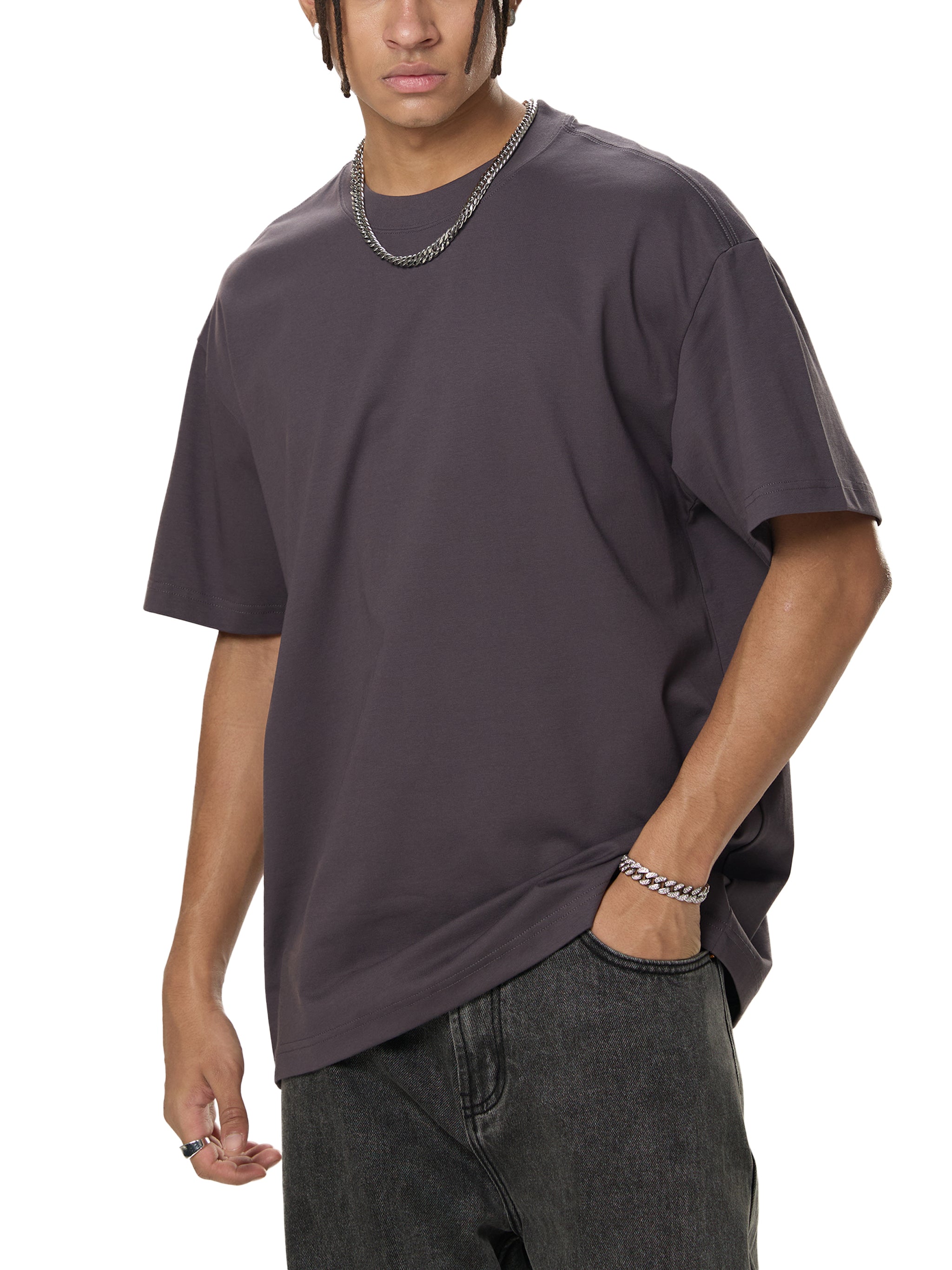 Man in oversized charcoal t-shirt and black jeans, modern streetwear style
