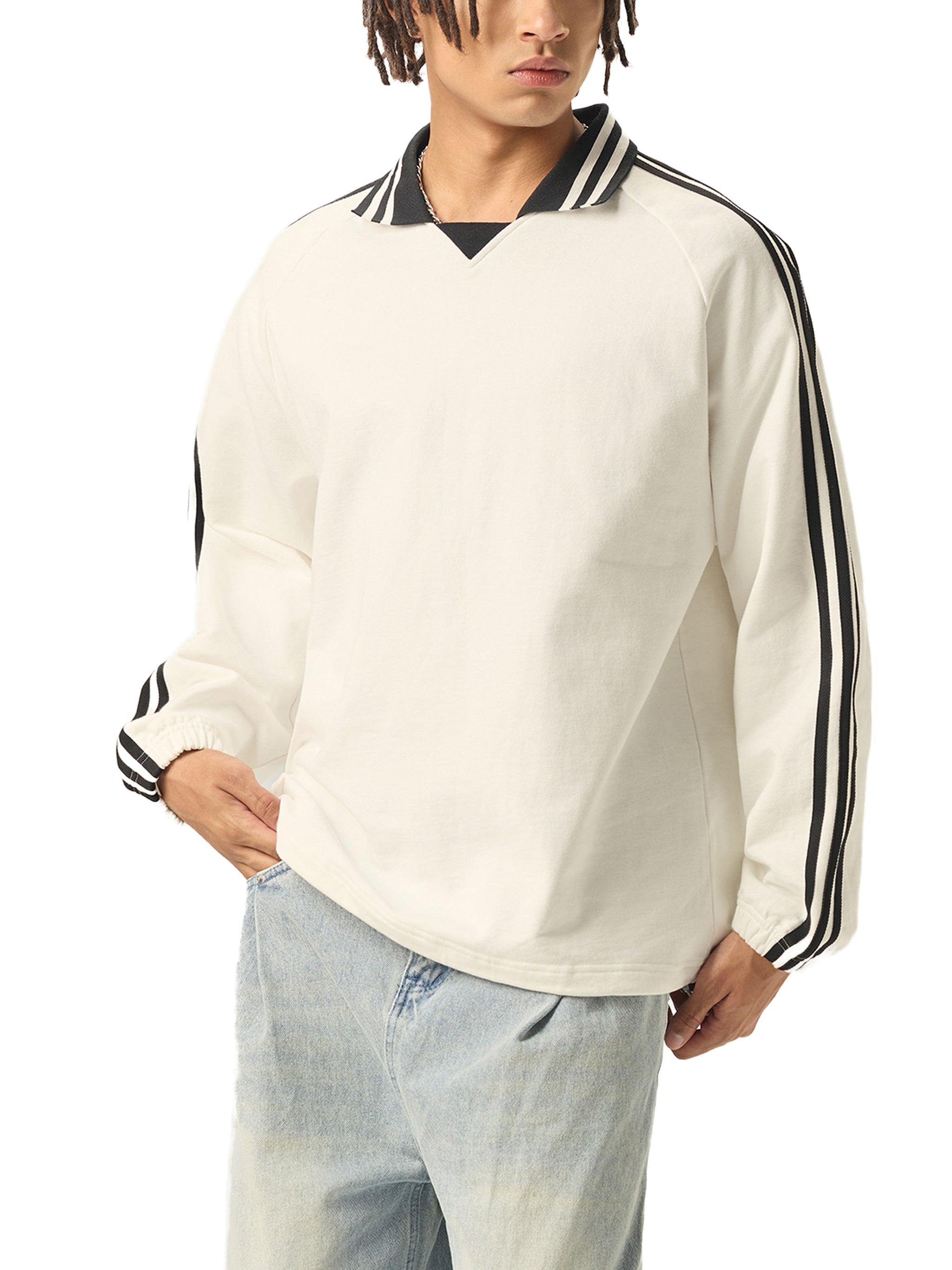 Man wearing oversized white streetwear sweatshirt with black striped collar and sleeves.