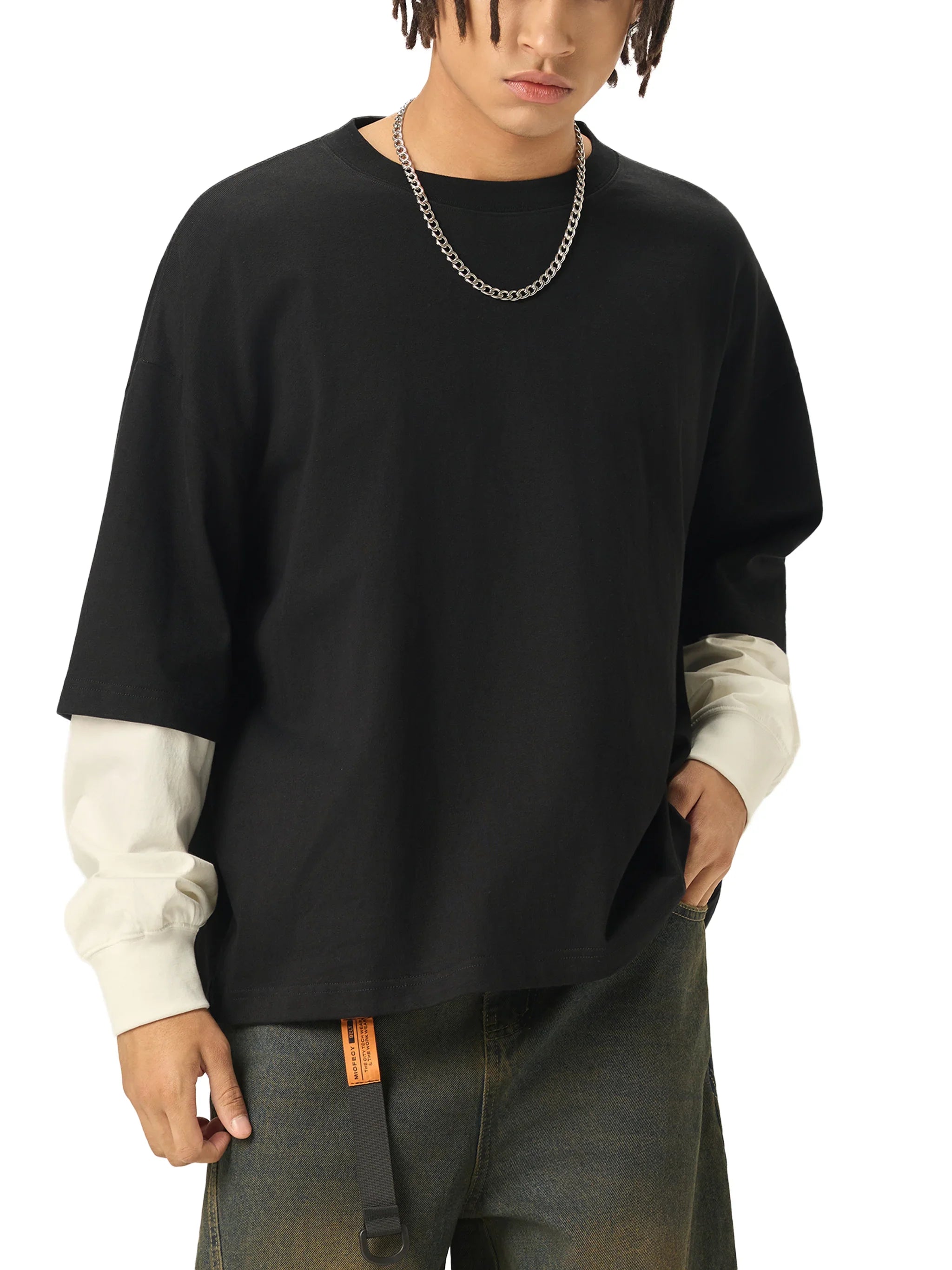 Man wearing oversized black t-shirt with white long sleeves and chain necklace, urban style