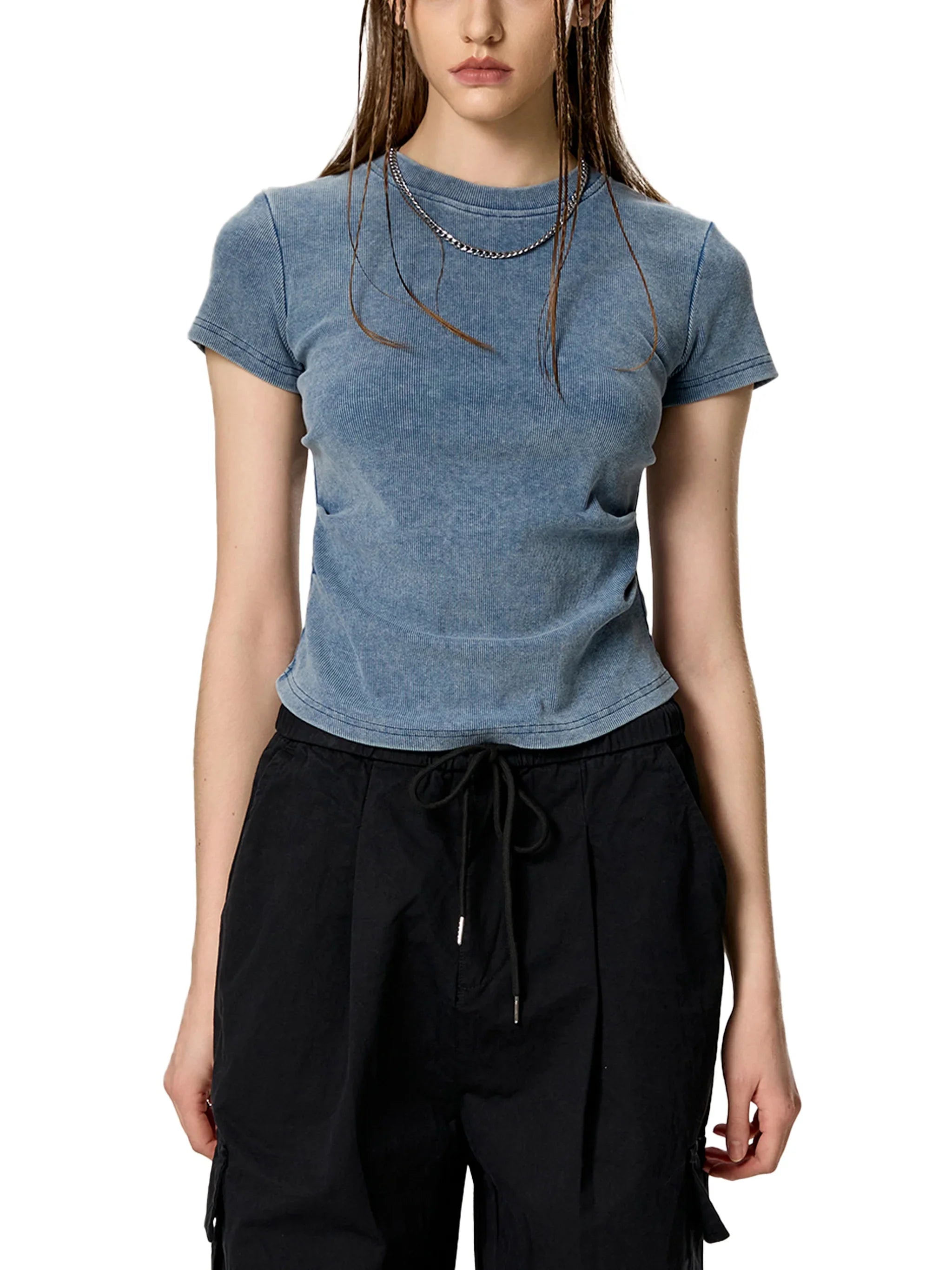 Woman wearing fitted blue washed t-shirt with black drawstring pants, urban streetwear style
