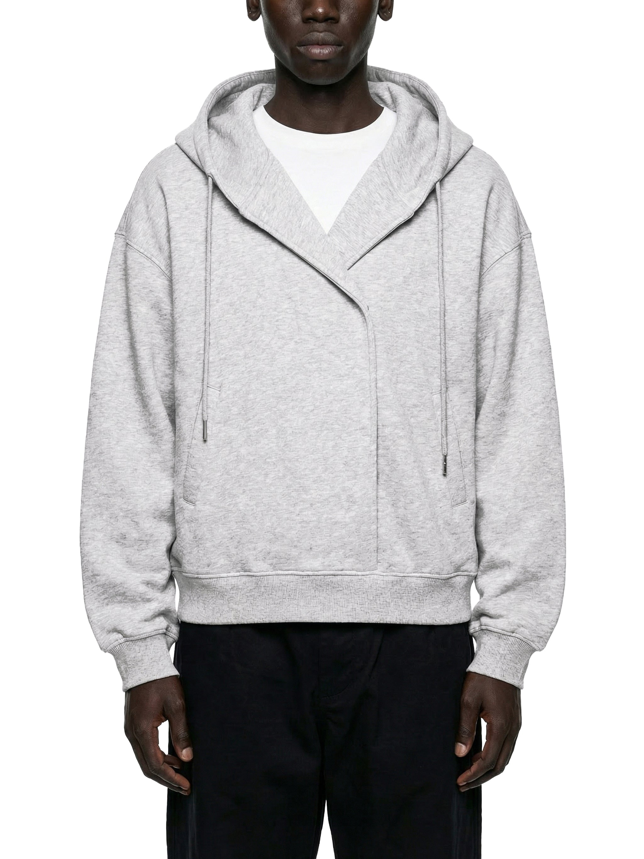 Man wearing an oversized light grey zip hoodie with drawstrings, paired with dark pants